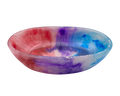 A shallow round resin bowl featuring a marbled tie-dye pattern of pink, purple, and blue on a white base, isolated on a white background.