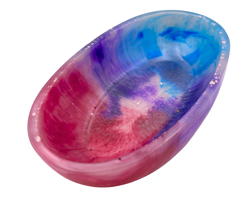 A shallow round resin bowl featuring a marbled tie-dye pattern of pink, purple, and blue on a white base, isolated on a white background.