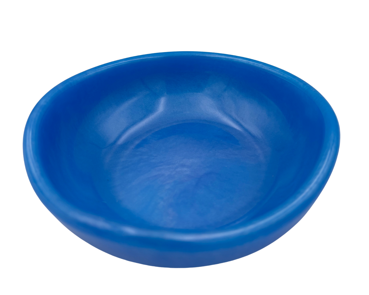A bright blue resin bowl with a shallow, wide rim, shown from a top-down perspective on a solid white background.