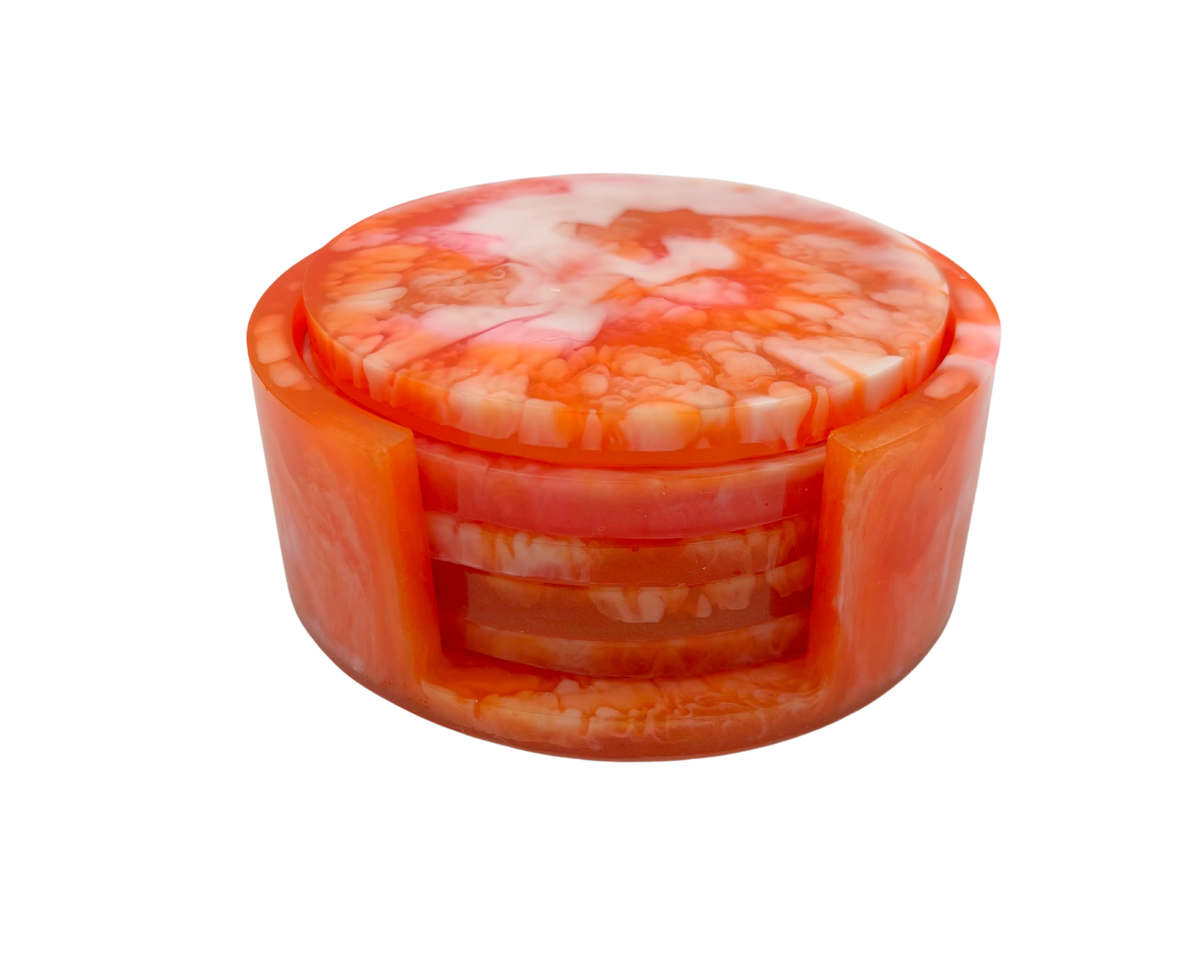 set of 5 round resin coasters with orange, white, and Pink marbled pattern, with a coaster holder, on a white background