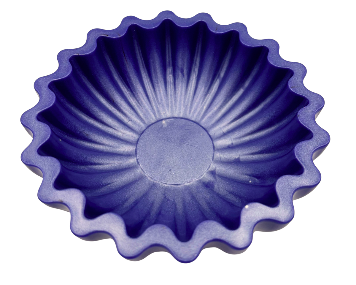 A scalloped-edge resin bowl in a deep periwinkle, shown from a top-down perspective on a solid white background.