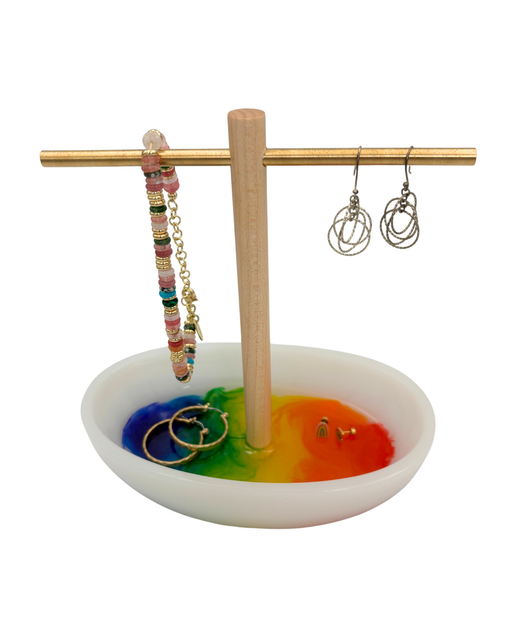 White resin tray with multicolored bottom with wooden and brass jewelry holder with earrings and bracelets