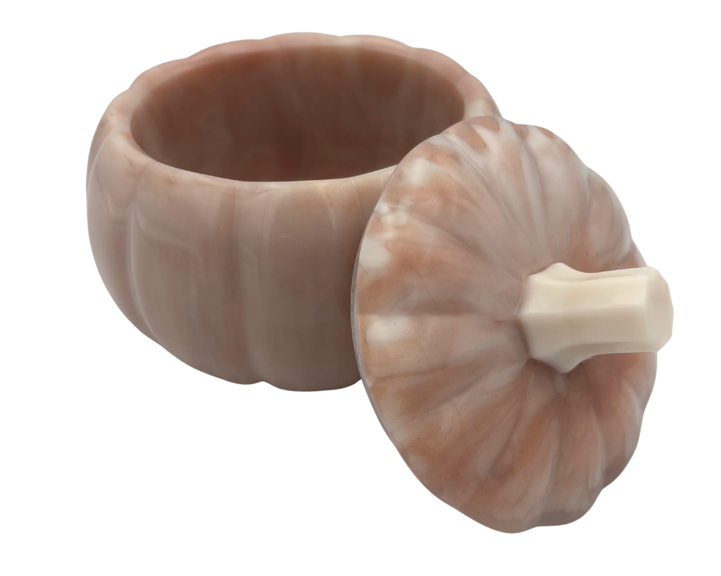 A small pumpkin-shaped lidded container or dish in a warm blush pink and cream marbled stone-like finish, shown on a plain white background.