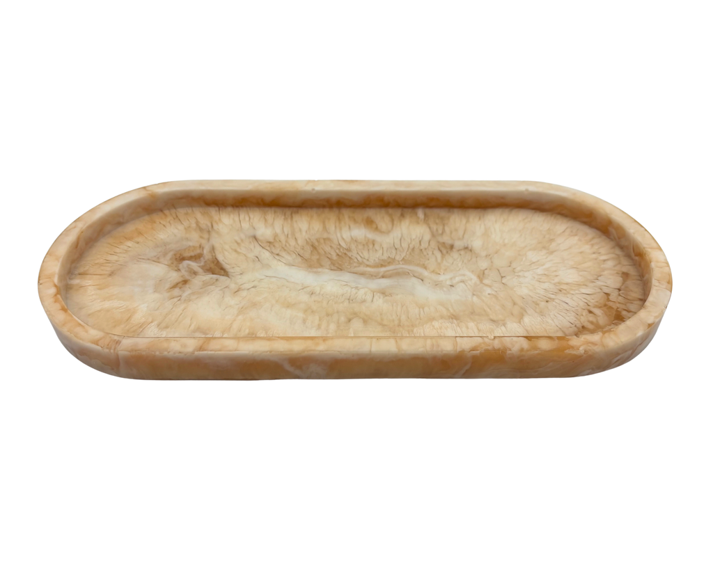 oval shallow resin tray with marbled beige and white patterns on a white background