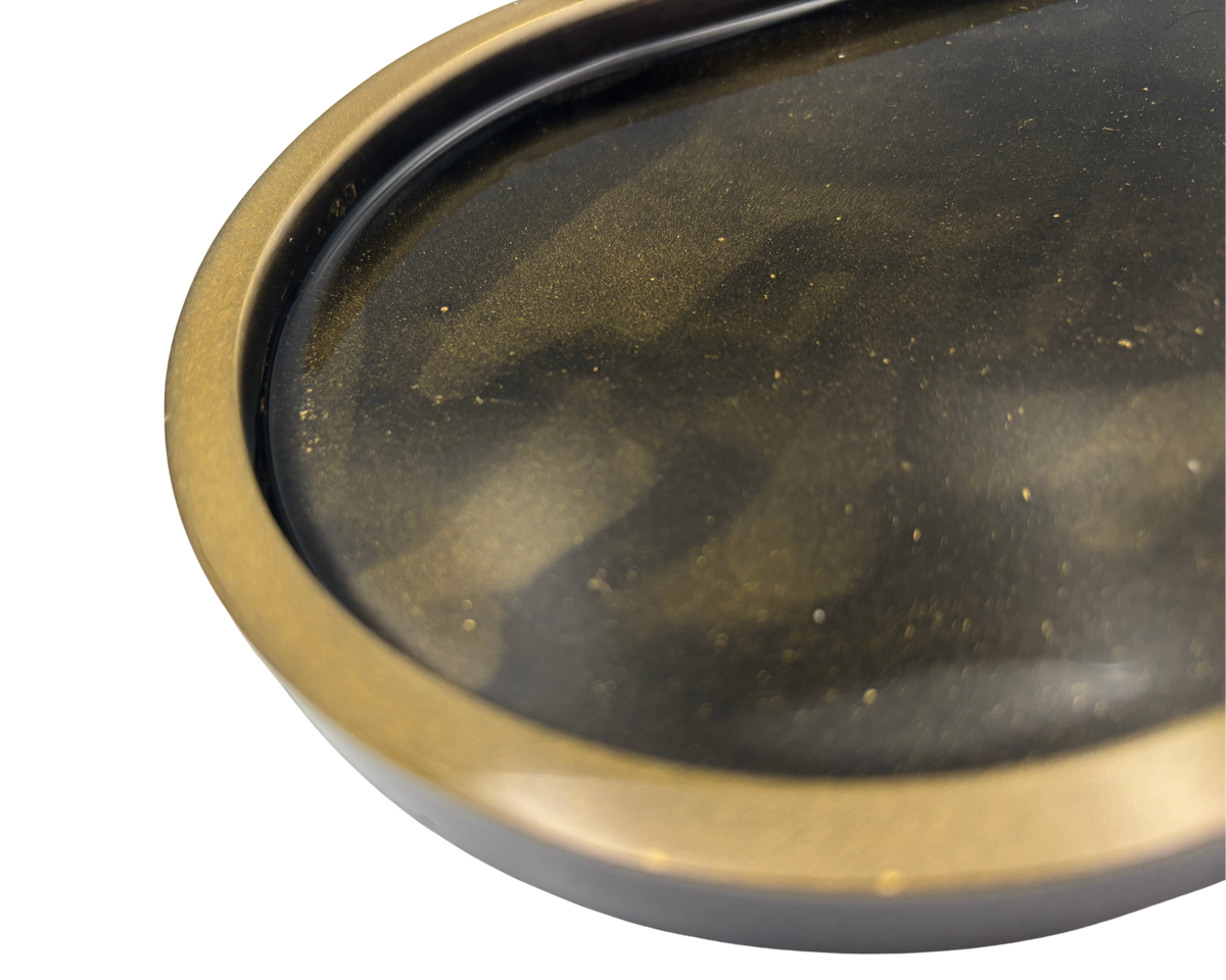 An oval-shaped tray with a dark black interior and a metallic bronze-gold rim, shown against a plain white background.