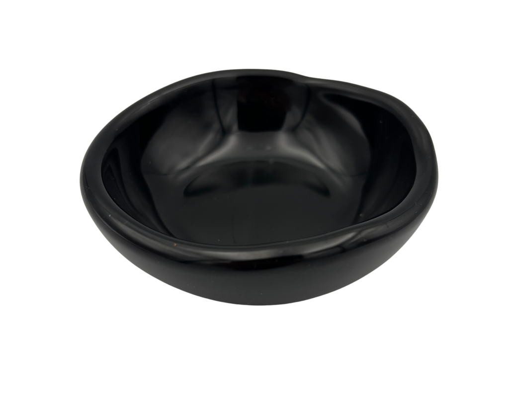 A small, glossy black resin bowl with an irregular, organic shape, shown from a top-down perspective on a solid white background.