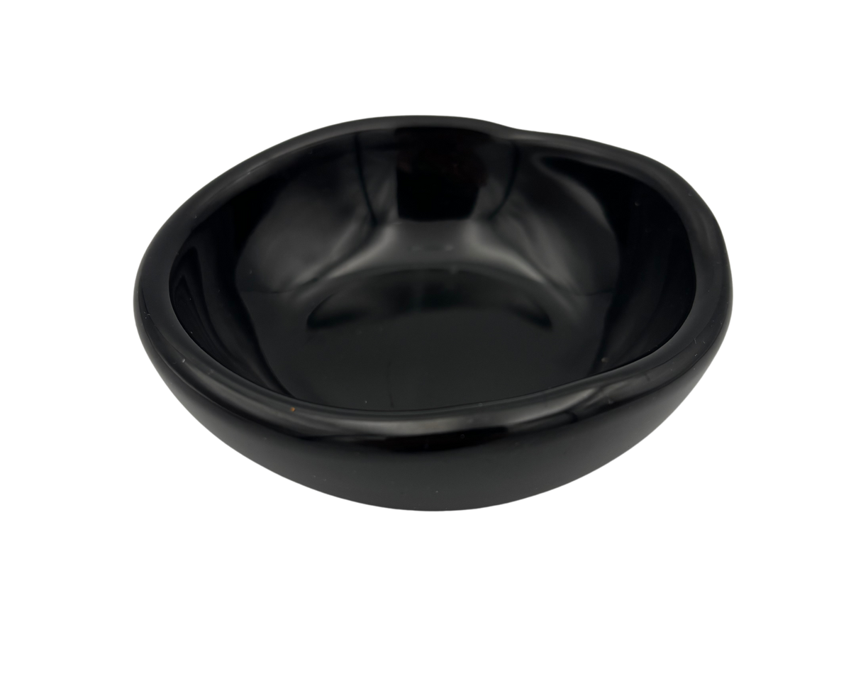 A small, glossy black resin bowl with an irregular, organic shape, shown from a top-down perspective on a solid white background.