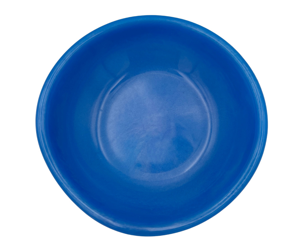 A bright blue resin bowl photographed from directly above on a plain white background.