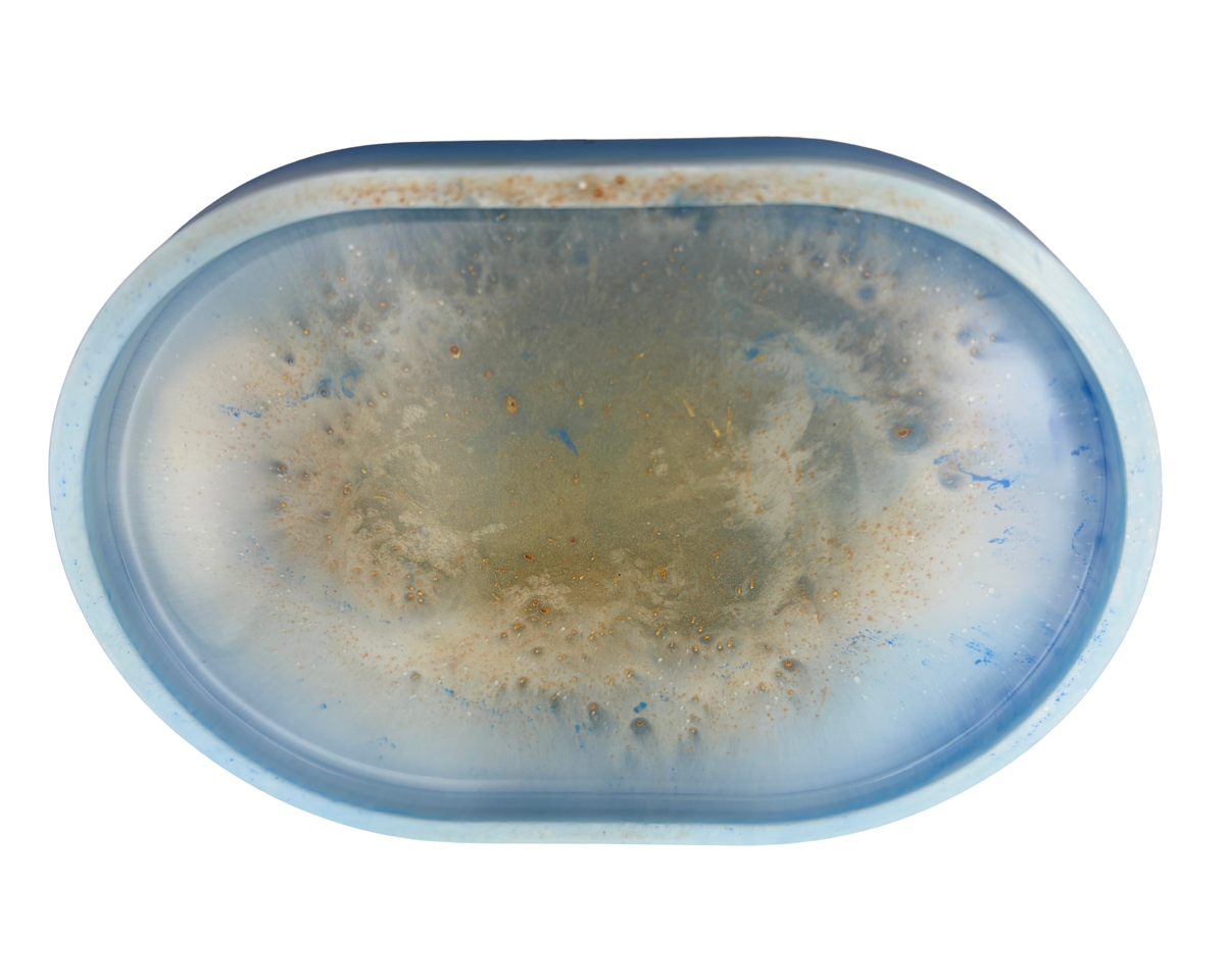 an oval resin tray with blue, white, and gold features on a white background