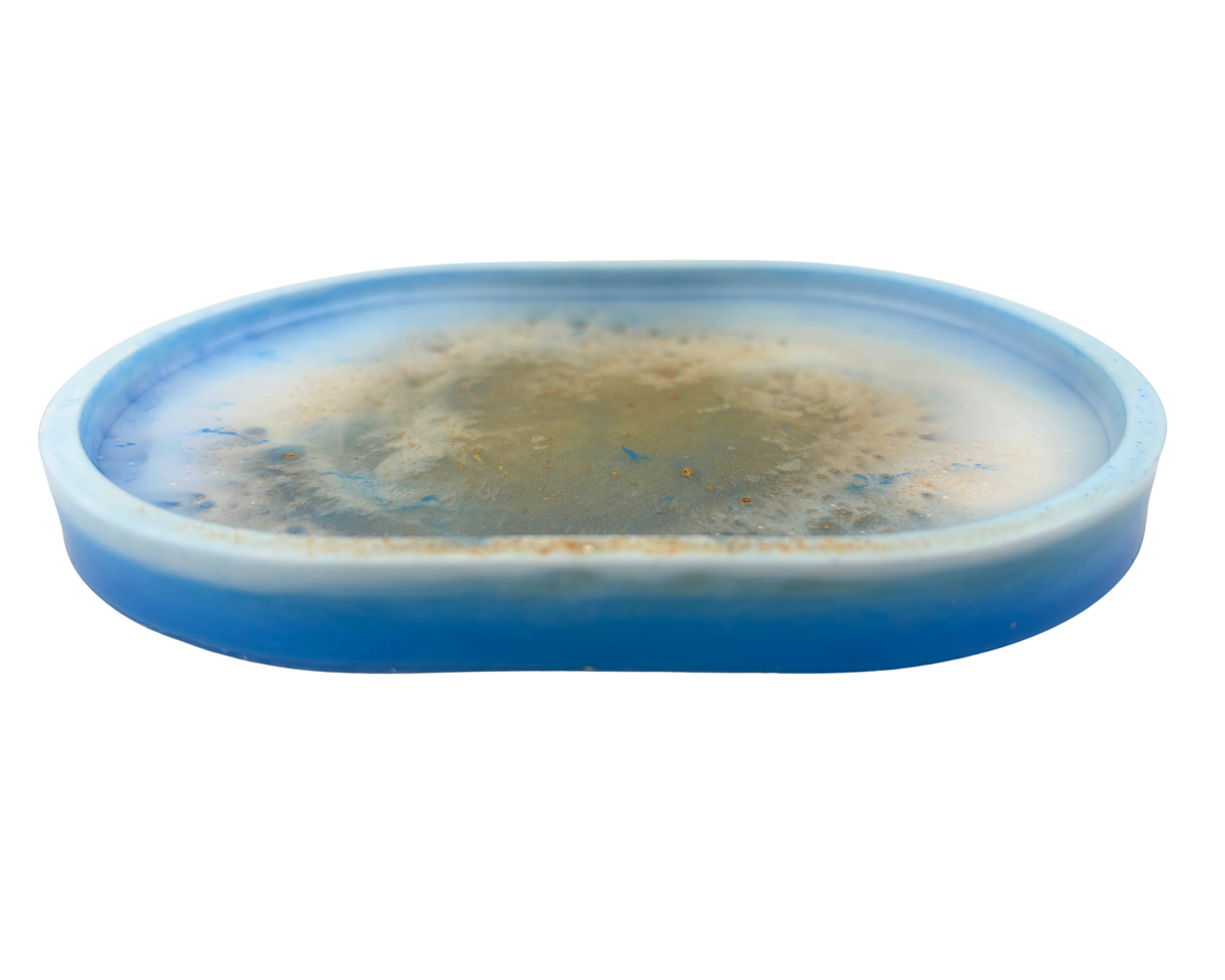 an oval resin tray with blue, white, and gold features on a white background