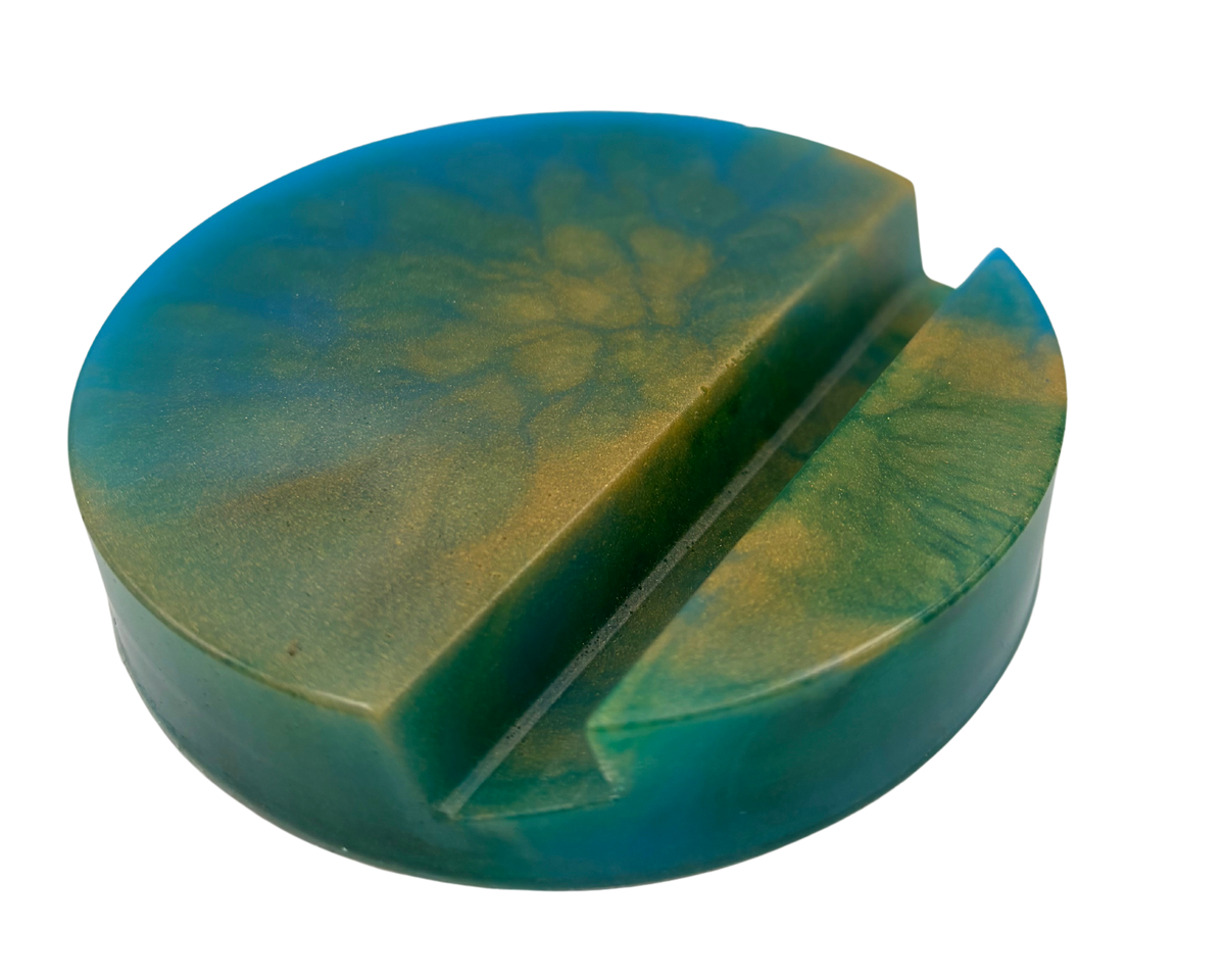 circular resin phone holder with blue, green, and gold swirls on white background