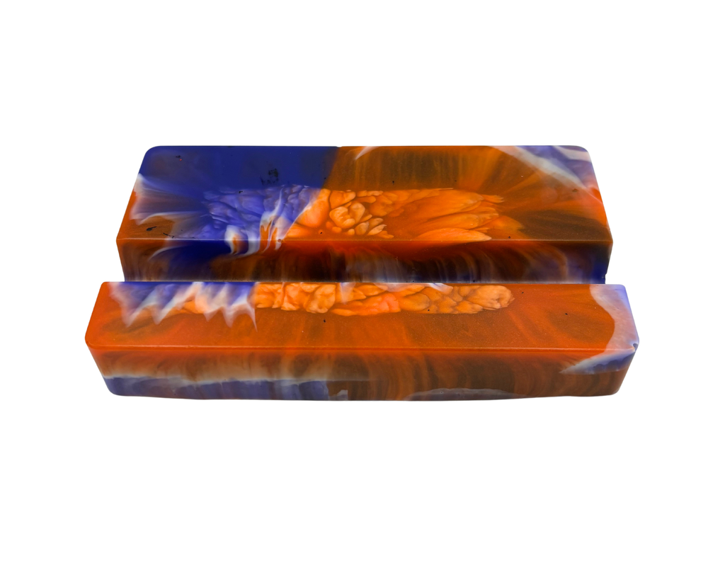 A mobile phone stand, featuring a marbled pattern of vibrant orange, deep blue, and white swirls with a textured bubbly finish.