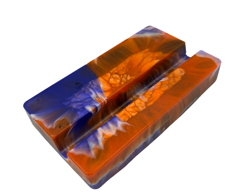A mobile phone stand, featuring a marbled pattern of vibrant orange, deep blue, and white swirls with a textured bubbly finish.