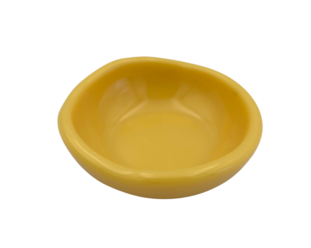 A small, shallow yellow resin bowl with a slightly irregular, organic shape, shown against a plain white background.