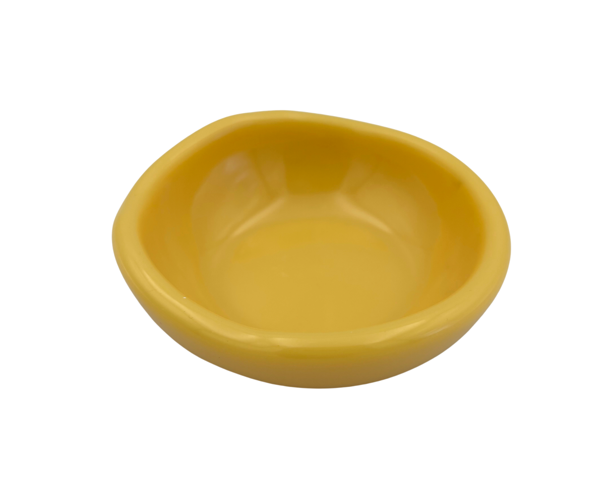 A small, shallow yellow resin bowl with a slightly irregular, organic shape, shown against a plain white background.