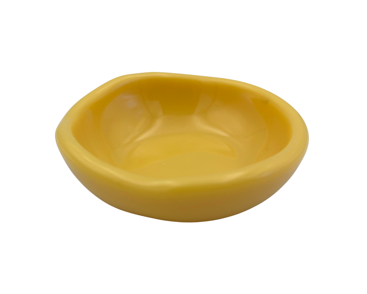 A small, shallow yellow resin bowl with a slightly irregular, organic shape, shown against a plain white background.