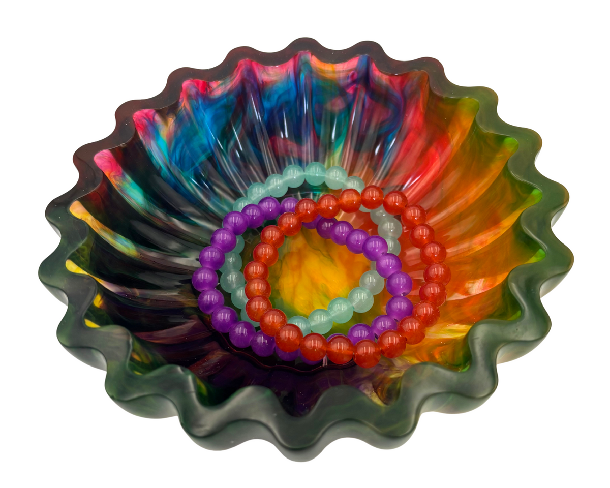 colorful resin bowl with scalloped edges holding bracelets