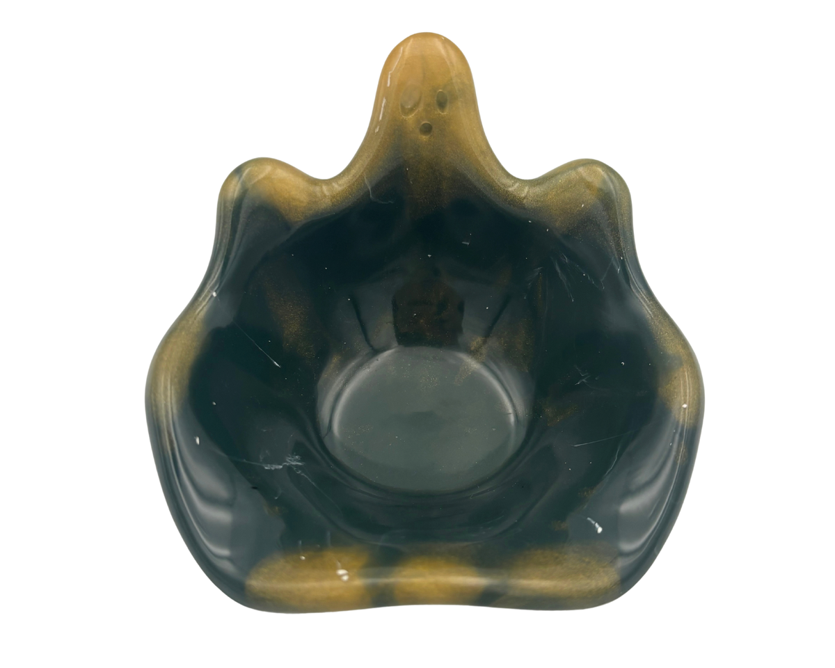 A small decorative bowl with a wavy, ghost silhouette, featuring a glossy dark green to black marbled finish with prominent golden-yellow veining and highlights, set against a plain white background.