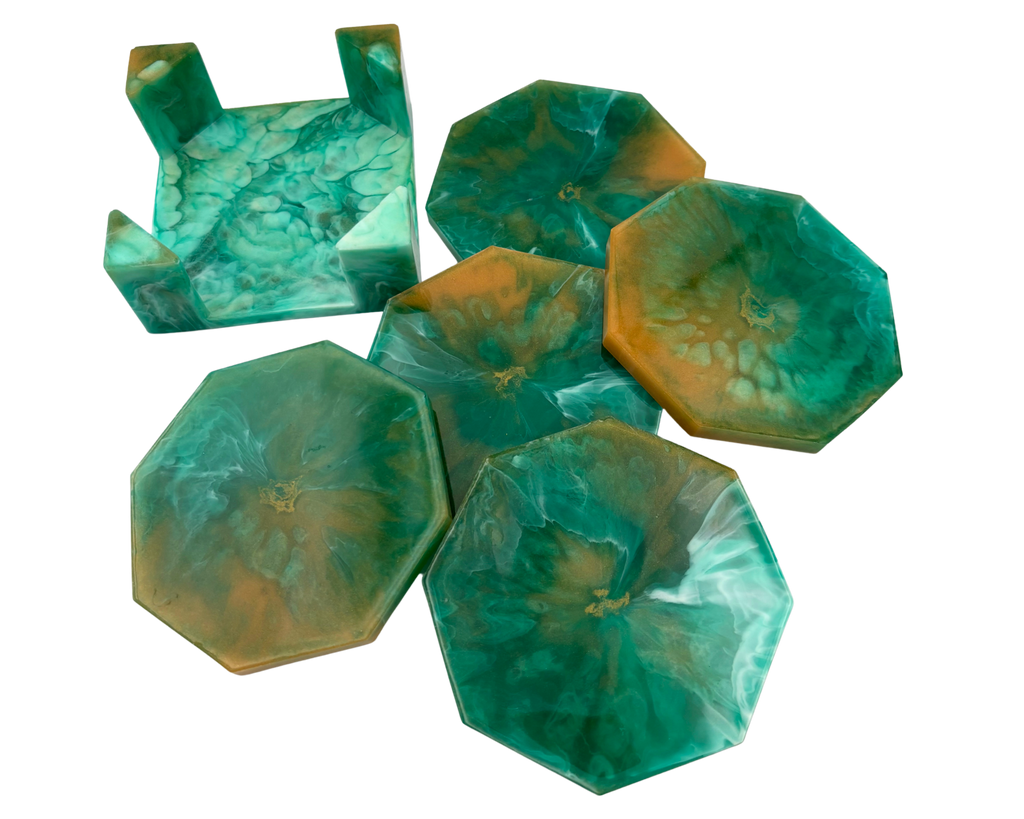 A set of octagonal resin coasters and a matching octagonal tray with a raised rim, featuring a marbled swirl pattern of green, teal, and amber-orange resin on a plain white background.