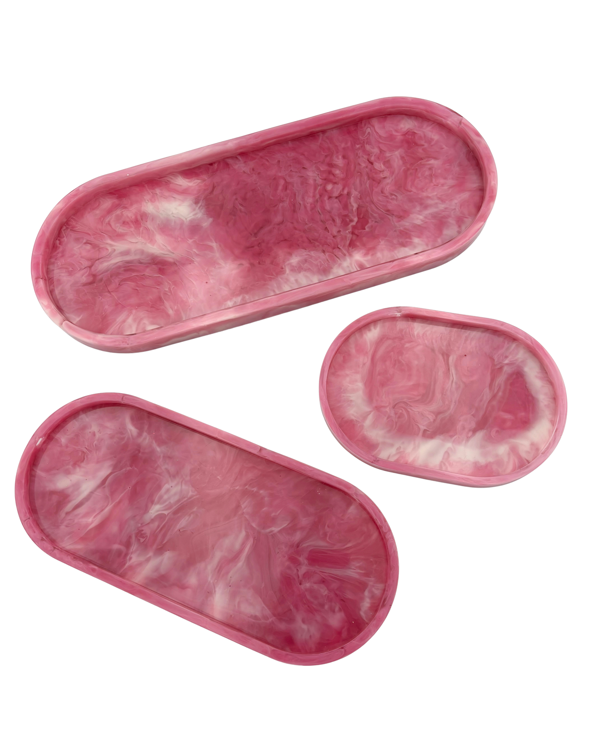 Three pink marbled resin trays with a swirled white pattern, shown on a solid white background.