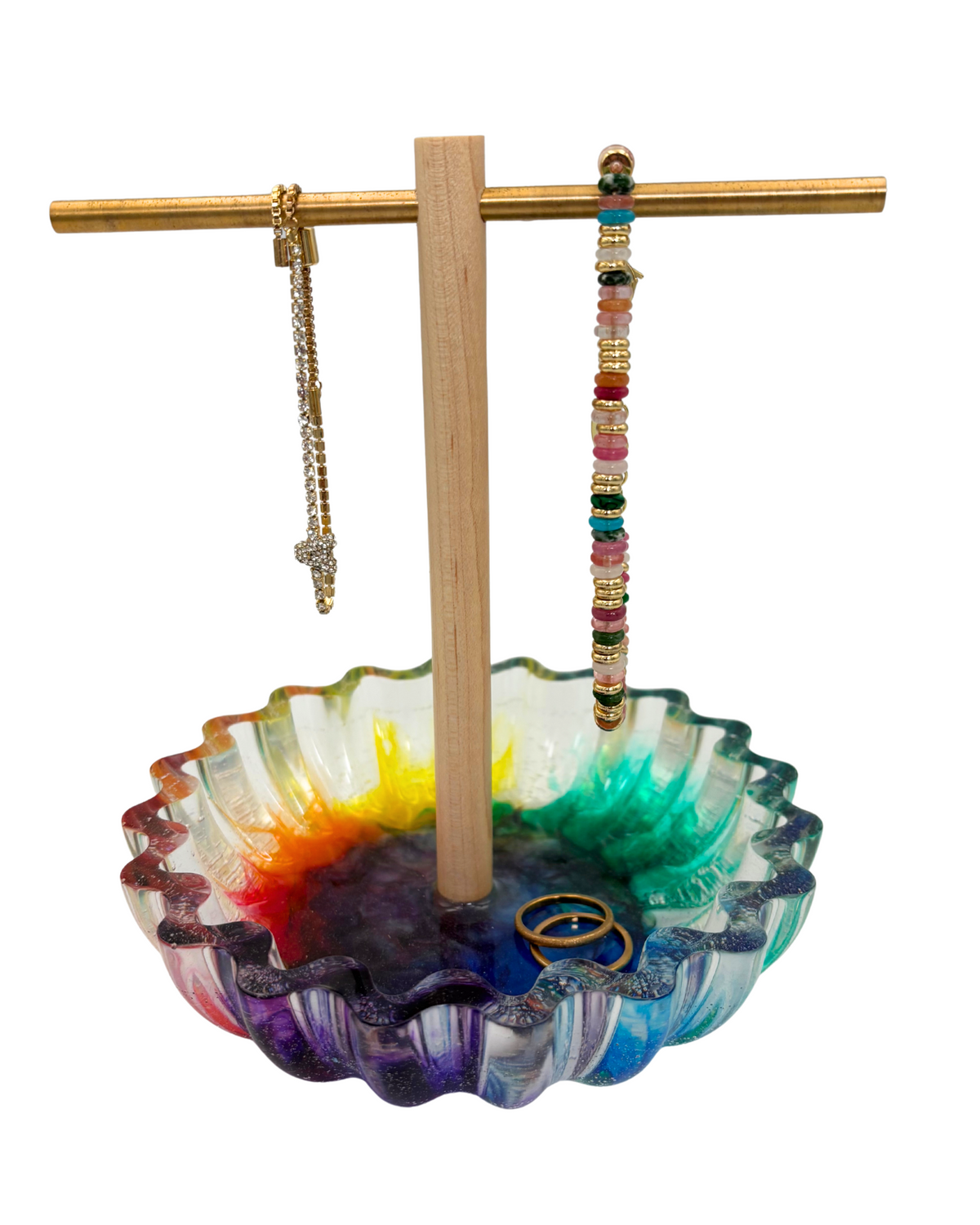 Colorful resin bowl with a wooden and brass jewelry tree holding bracelets and rings
