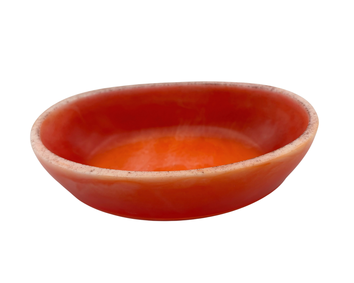 A small, shallow oval dish with orange swirls and a light rim, isolated on a white background.