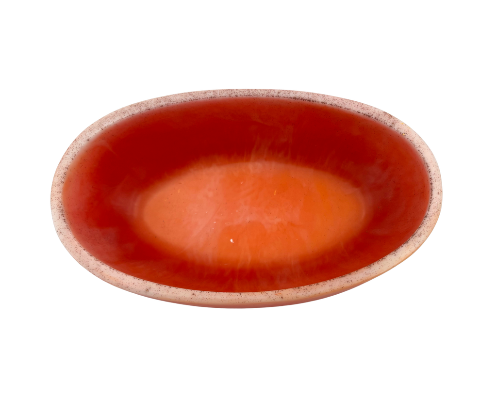 A small, shallow oval dish with orange swirls and a light rim, isolated on a white background.