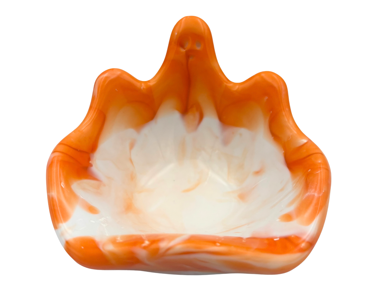 An orange and white marbled resin bowl with a ghost silhouette, photographed against a solid white background.