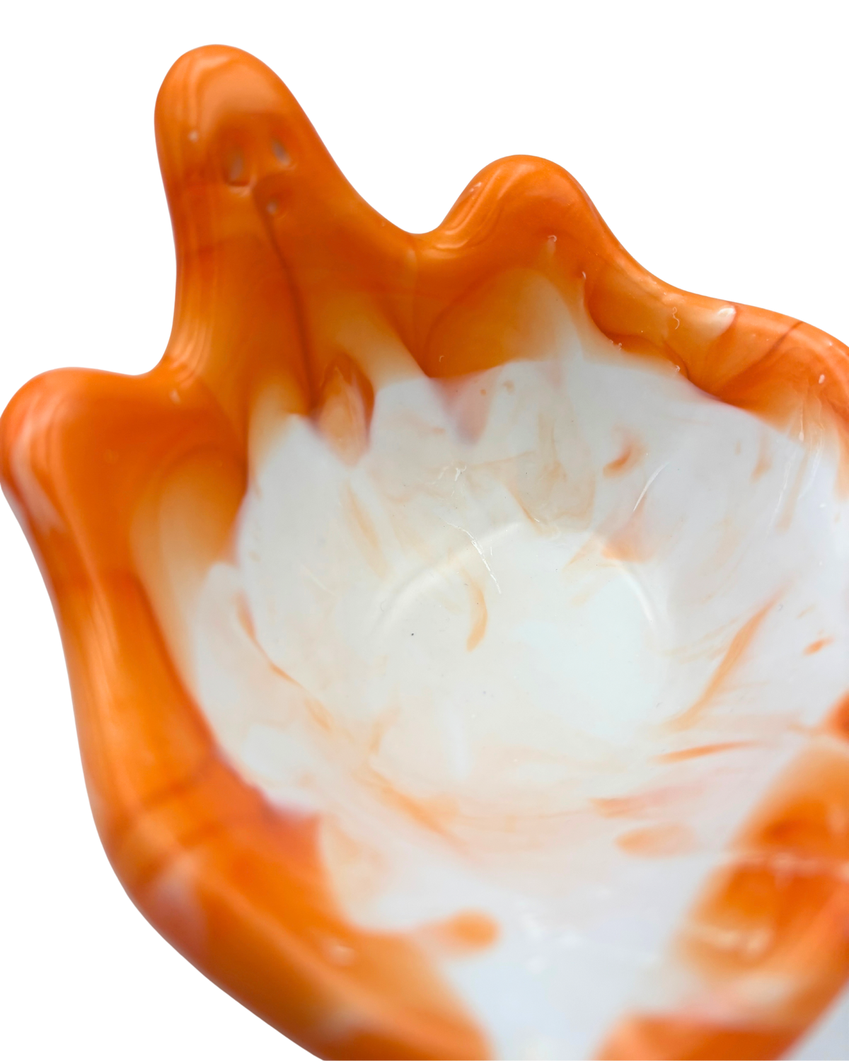 An orange and white marbled resin bowl with a ghost silhouette, photographed against a solid white background.