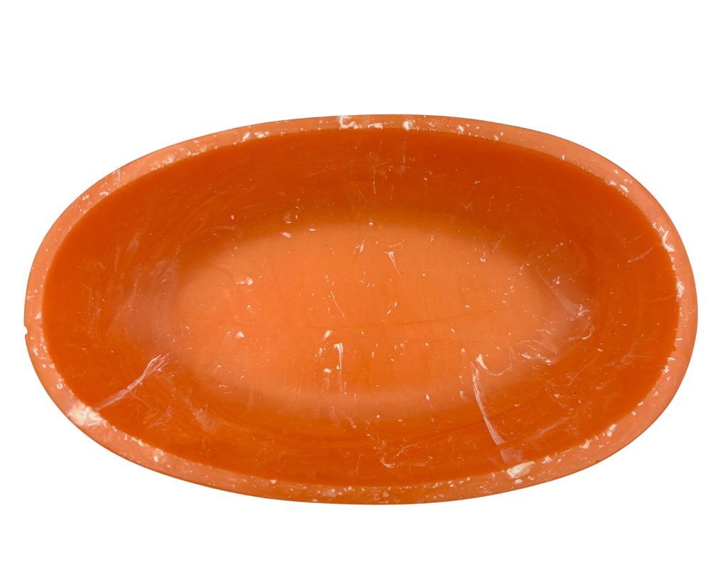 An orange resin bowl with a shallow depth, shown from a top-down perspective on a solid white background.