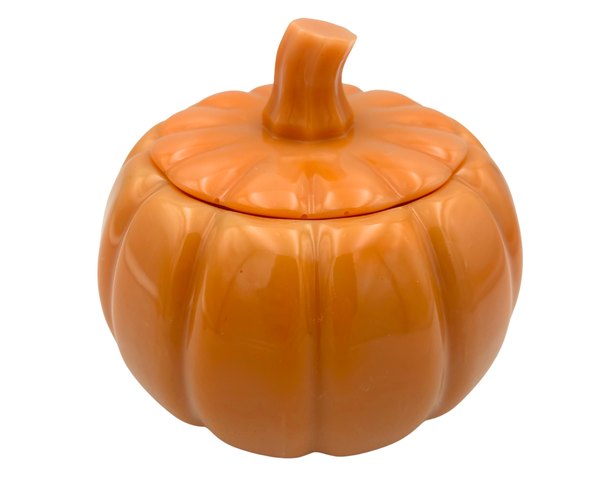 An orange pumpkin-shaped resin container with a matching lid and a short stem, shown on a plain white background.