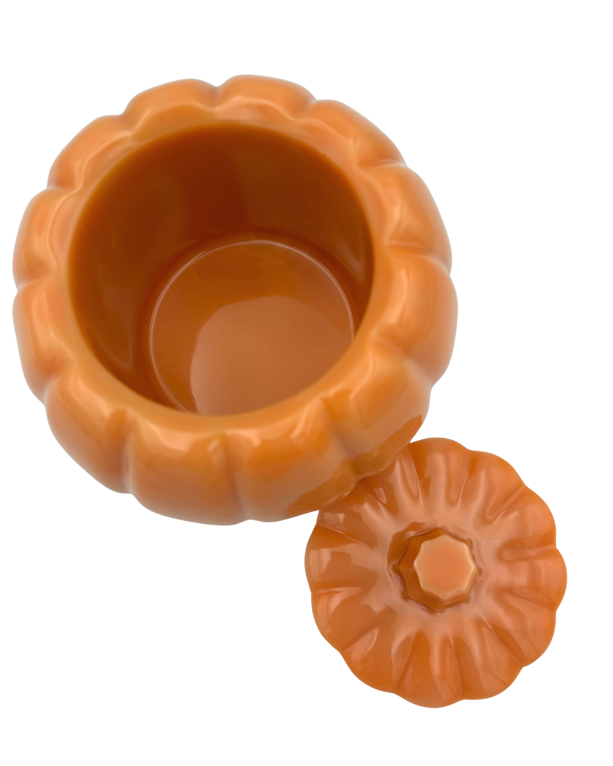 An orange pumpkin-shaped resin container with a matching lid, shown on a plain white background.