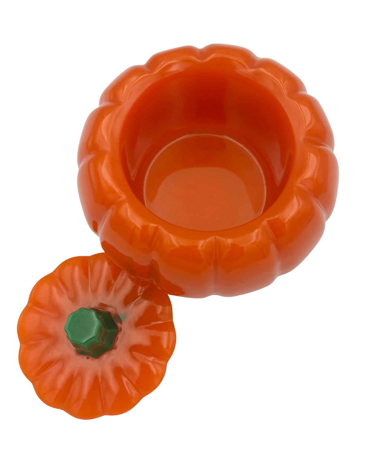 An orange pumpkin-shaped container with a matching lid and a green stem, shown on a plain white background.