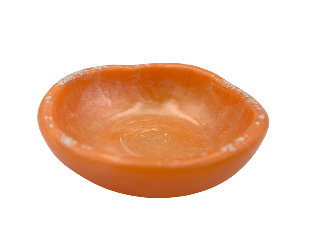 An orange resin ring dish, photographed from a top-down angle on a solid white background.