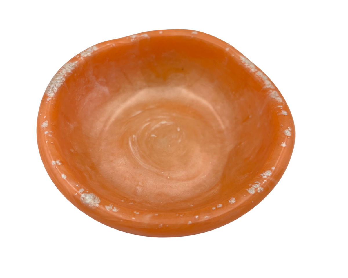An orange resin ring dish, photographed from a top-down angle on a solid white background.