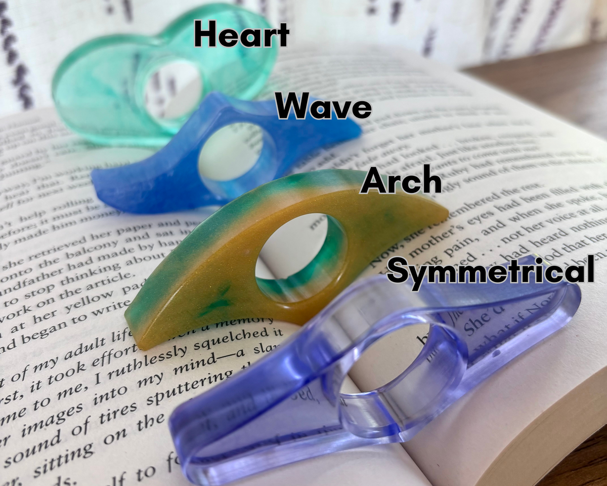 Four page holders  in different shapes and colors (heart, wave, arch, and symmetrical) arranged on an open book with text labels overlaid.