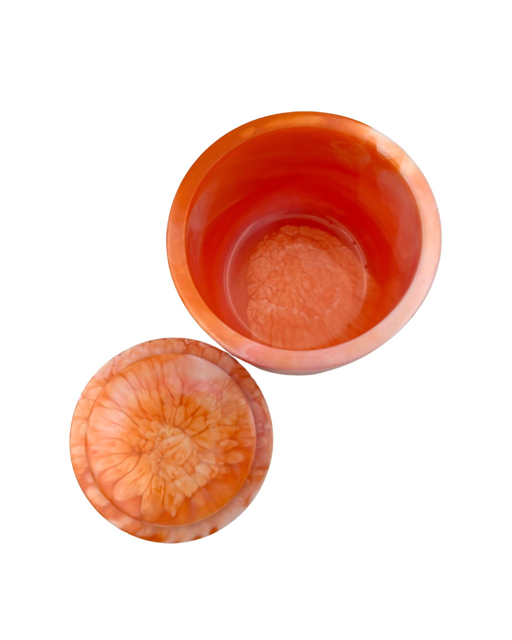 A cylindrical container with a lid, featuring a marbled design of vibrant orange, pink, and white layers, isolated on a white background.