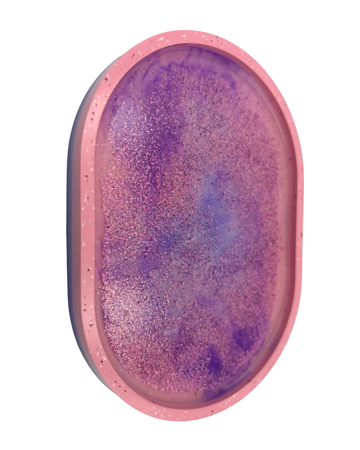 An oval-shaped pink tray or mold containing a purple glittery resin surface, shown against a plain white background.