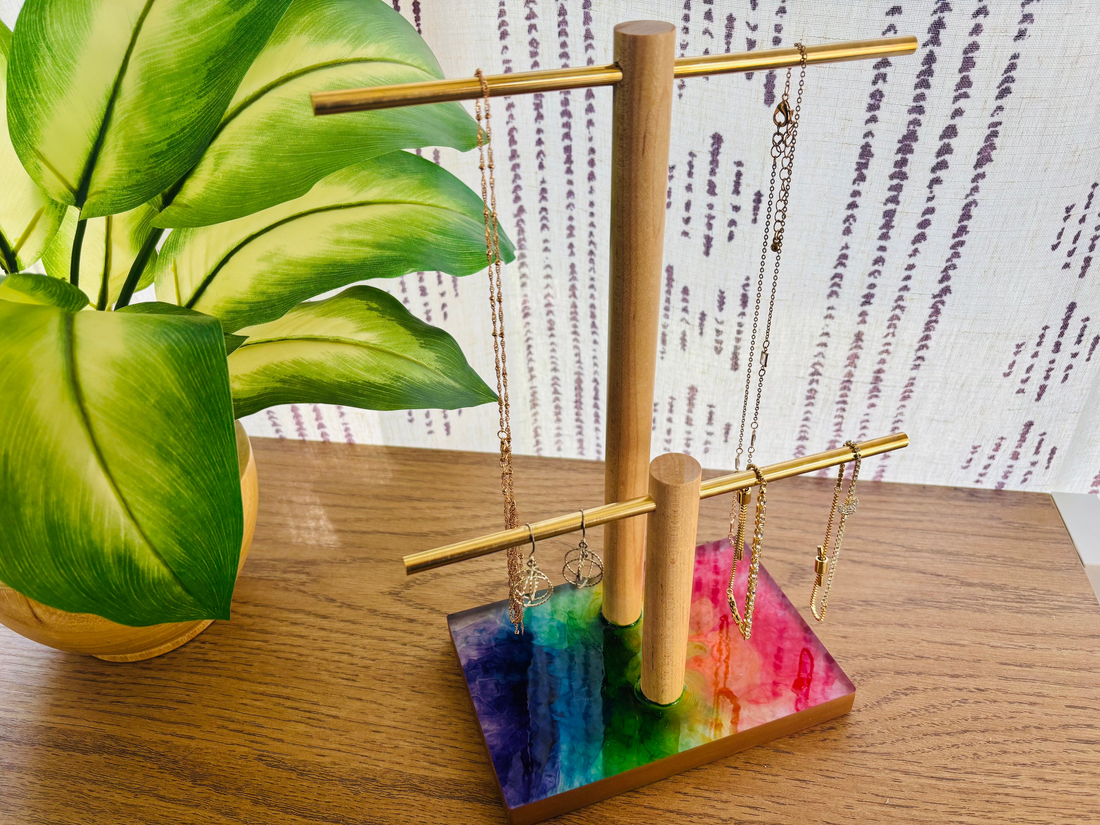 Jewelry stand with colorful base and hanging necklaces on table
