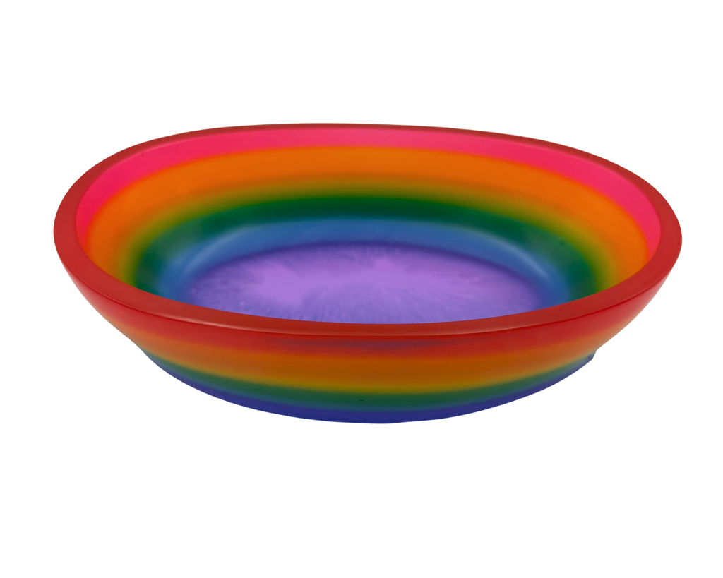 A shallow oval resin bowl with a vibrant rainbow gradient design, featuring concentric bands of red, orange, yellow, green, blue, and purple on a plain white background.
