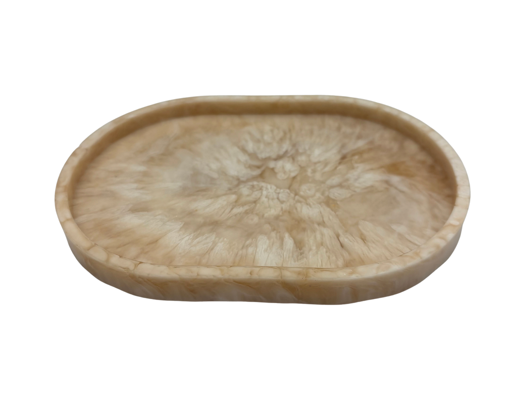 small oval Resin dish with beige and white marbled pattern on a white background