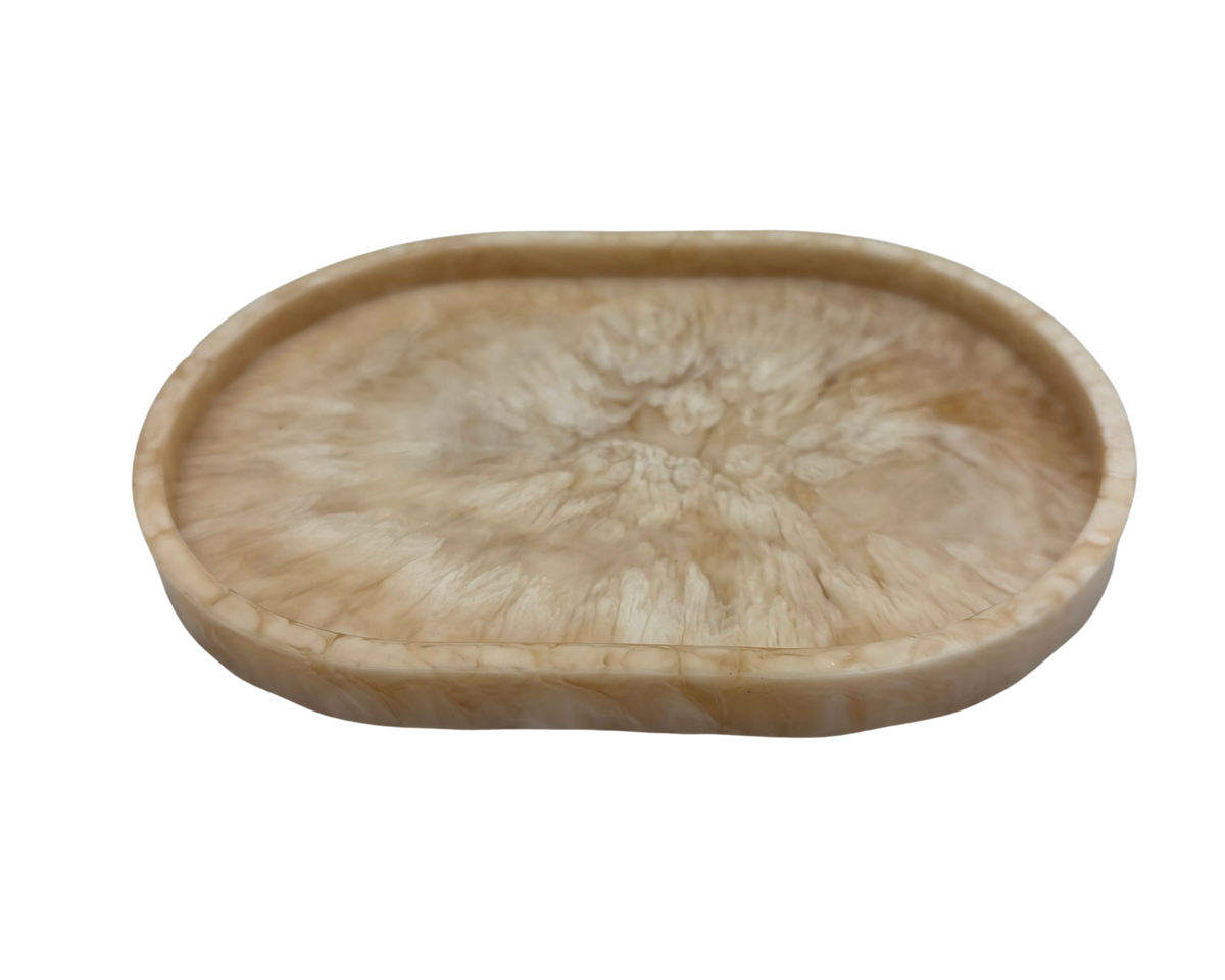 small oval Resin dish with beige and white marbled pattern on a white background