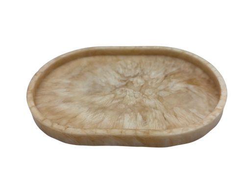 small oval Resin dish with beige and white marbled pattern on a white background