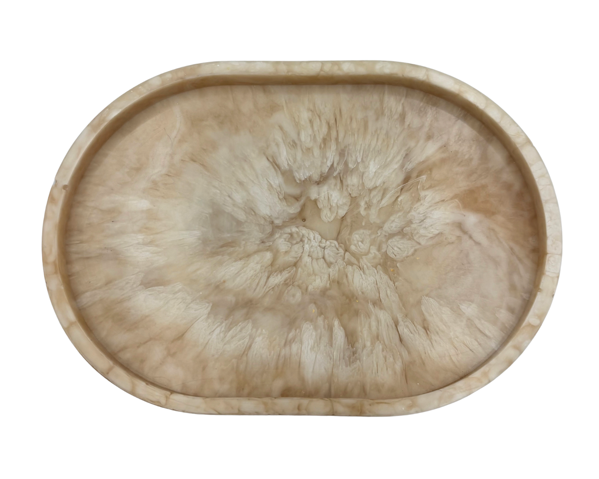 small oval Resin dish with beige and white marbled pattern on a white background