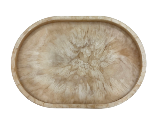 small oval Resin dish with beige and white marbled pattern on a white background