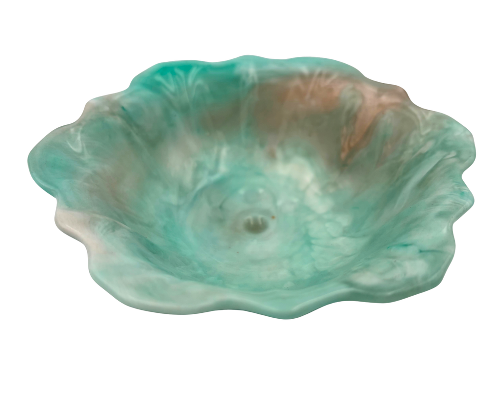 A handmade resin bowl with petal-shaped rim, featuring a marbled swirl of mint green, teal, white, and subtle peach-brown tones, isolated on a white background.