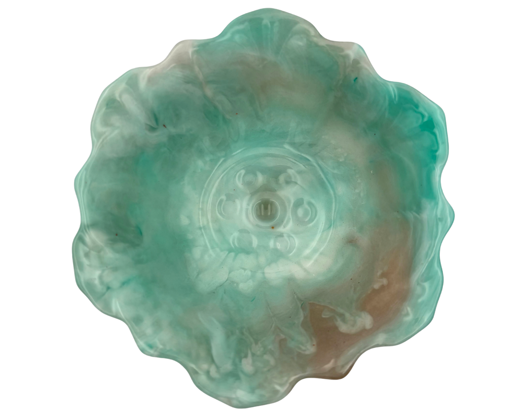 A handmade resin bowl with petal-shaped rim, featuring a marbled swirl of mint green, teal, white, and subtle peach-brown tones, isolated on a white background.