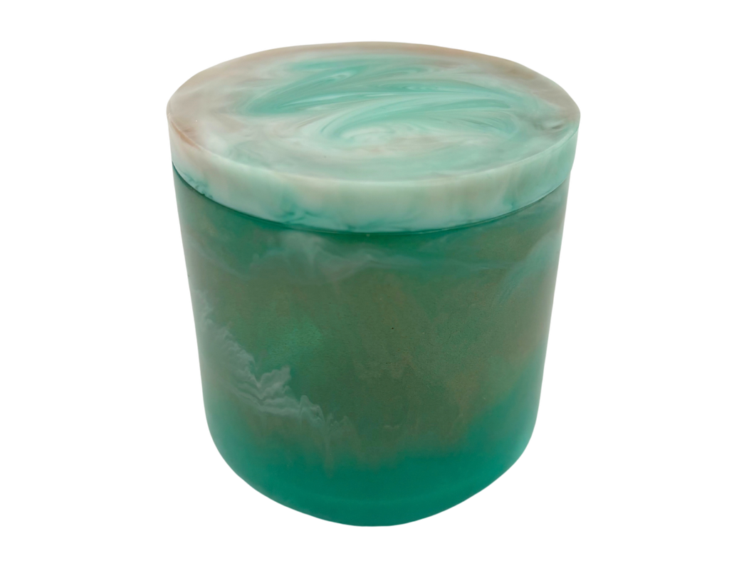 A cylindrical resin jar with a marbled green and white design, featuring a solid teal-green base and a swirled white and light teal lid.