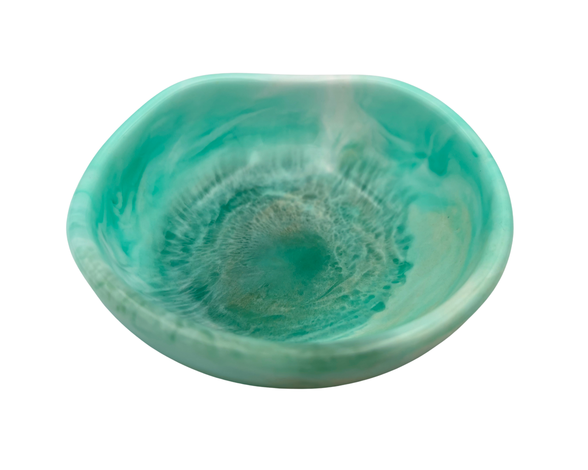 A small organic-shaped resin bowl with a swirled turquoise, teal, and mint green glaze, shown from a top-down perspective on a white background.