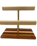 A wooden jewelry display stand with two horizontal bars mounted on a striped wood base, shown against a plain white background.